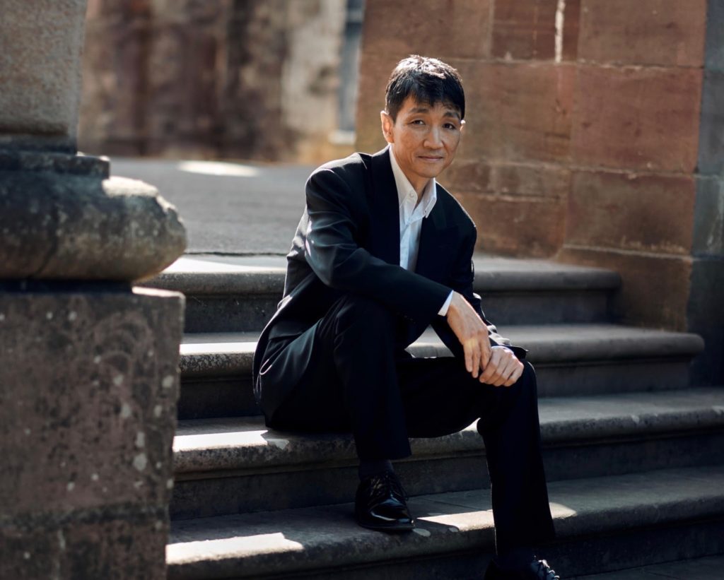 Takuhiro Murayama Pianist sitzt auf der Treppe.